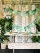 Mise en situation sur une table des gobelets en carton tropical vert avec motifs feuilles de palmier