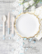 Mise en scène de table des petites assiettes en carton bordures ciselées pour fête blanches et dorées