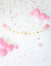 Mise en situation avec ballons et confettis de la guirlande en carton baby girl pour baby shower