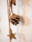 Gros plan sur la pomme de pin pailletée de la suspension pommes de pin et étoiles bois pour décoration paillettes cuivre