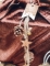 Mise en situation sur un paquet cadeau de la suspension pommes de pin et étoiles bois pour décoration paillettes cuivre