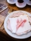 Mise en situation sur table des assiettes en carton rose poudré pour fête avec bordures dorées