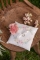 Mise en situation champêtre sur chaise en bois du coussin d alliances mariage fleuri