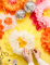 Détail de l assemblage manuel des fleurs géantes en papier à suspendre rose jaune et orange