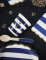 Mise en scène de table des serviettes festonnées en papier marinière bleu marine et blanc à bords dorés avec ancre