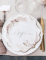 Mise en situation sur table des assiettes baptême pampas et fleurs de coton