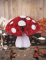 Mise en scène avec bougies de la décoration champignon alvéolé pour fête rouge et blanc