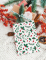 Détail des motifs de feuilles et baies de la pochette cadeau houx de Noël en papier