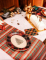 Mise en scène avec bûche de Noël du plateaux en carton tartan de Noël