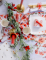 Mise en situation sur une table de la guirlande style champêtre feuillages et fleurs rouges