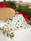Détail du bord doré des serviettes en papier festonnées houx pour Noël